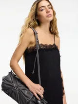 Vestido midi negro de estilo lencero con breteles finos regulables y encaje en el escote y ruedo.
