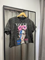 Remera negra jaspeada de corte cropped con estampa de la portada de la revista Vogue con imagen de Frida Kahlo intervenida con un rayo azul.