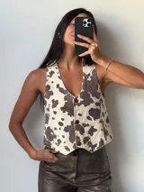 Chaleco con estampado de vaca, con cuello en V y cierre frontal con botones.