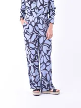 Pantalón de vestir de tiro alto con estampado abstracto en tonos celeste y negro.