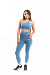 Conjunto deportivo celeste compuesto por calza larga de tiro alto y top deportivo de un hombro con logo estampado.