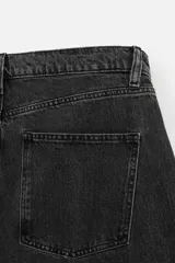 Pantalón de jean negro de corte amplio, estilo balloon fit, con cinco bolsillos, efecto lavado y cierre frontal con botones.