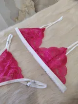 Conjunto de lencería fucsia de encaje floral, compuesto por un corpiño triangular sin aro y una tanga con tiras finas blancas.