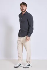 Camisa de manga larga color gris oscuro, con cuello clásico y cierre frontal con botones.