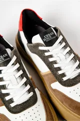 Zapatillas deportivas bajas con paneles en marrón, blanco y negro. Suela gruesa color caramelo.