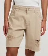 Bermuda masculina de sarga blanca, modelo slim, con rotos (destroyed) en la parte delantera de ambas piernas. Presenta cintura fija con trabillas, cierre de botón y cremallera, y bolsillos.