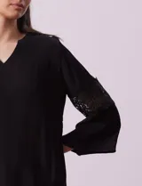 Blusa negra de gasa bambula con cuello a la base y escote en V. Tiene mangas 3/4 amplias con apliques de crochet.