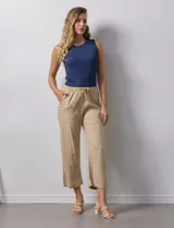 Pantalón color beige, marca Dash, de corte cropped y pretina trasera elastizada. Presenta bolsillos delanteros y traseros.