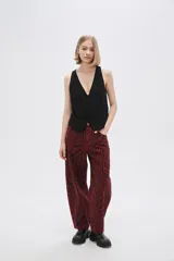 Pantalón de jean de tiro alto con estampado animal print de cebra en tonos borgoña y negro.