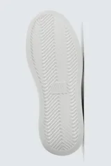 Zapatillas deportivas negras con detalle en blanco en el talón y suela blanca con volumen.