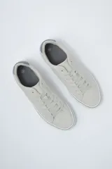 Zapatillas acordonadas de cuero sintético color gris claro, con suela blanca y detalles en gris oscuro en el talón y en la línea superior de la suela.