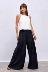 Pantalón palazzo plisado color azul marino, de tiro alto con bolsillos laterales y cierre frontal con botón.