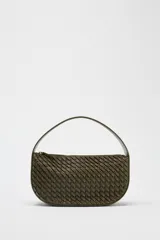 Bolso de mano color verde oliva con efecto trenzado. Tiene asa corta y correa larga extraíble. El cierre es con cremallera metálica.