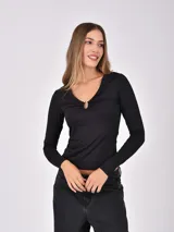 Remera negra de manga larga con escote en V y detalle de argolla metálica en el centro del busto.