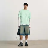 Short de jean azul con corte ancho, bolsillos delanteros y traseros, y ruedo desflecado. Presenta un parche con el logo de la marca en uno de los bolsillos traseros y etiqueta de cuero en la cintura.