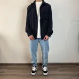 Sobrecamisa color beige de pana con cuello clásico, cierre con botones y bolsillo de parche en el pecho. Corte recto y mangas largas con puños abotonados.