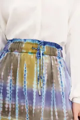 Minifalda de viscosa con estampado batik en tonos azul, violeta y amarillo. Cintura elastizada con cordón de ajuste.