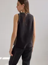 Chaleco tejido color crema con cuello redondo y rayas verticales marrones.