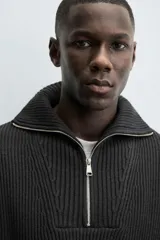 Jersey de punto perlado negro, de corte relaxed fit, con cuello perkins y cierre frontal de cremallera.