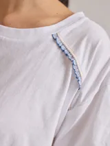 Remera negra de algodón con mangas cortas con detalle de calado y bordado en los hombros y mangas. Corte recto con cintura ajustable con cordón.