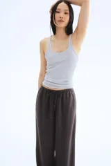 Pantalón recto gris oscuro de tejido vaporoso en mezcla de lino. Modelo holgado con elástico y cordón de ajuste en la cintura, bolsillos laterales y traseros insertados.