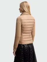 Cárdigan color beige con cierre frontal, mangas largas de punto acanalado y cuerpo acolchado con patrón horizontal.