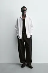 Camisa blanca de manga larga, corte slim fit, con cuello italiano y cierre frontal de botonadura.