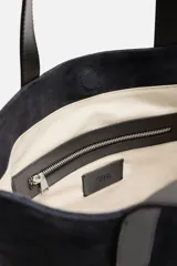 Bolso tipo shopper fabricado en piel de alta calidad con acabado serraje color negro. Tiene compartimento principal con cierre de imán, bolsillo interior con cremallera y asas de mano de piel.