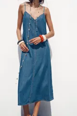 Vestido midi de denim azul, con escote en pico y tirantes finos.