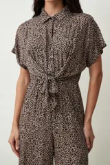 Mono largo negro de corte palazzo con camisa de mangas cortas con botones y lazo en la cintura.