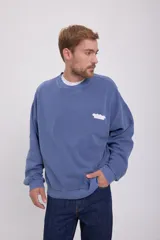 Buzo azul de manga larga y cuello redondo, con calce oversize y logo estampado en el pecho.