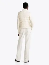 Chaleco acolchado color blanco con cuello alto, cierre frontal con cremallera, dos bolsillos laterales con cremallera y parche con logo en el pecho.