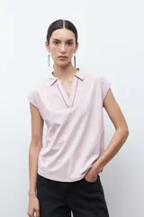 Remera de manga corta color rosa pálido, con cuello polo y escote en V con detalle de bordado en el borde.