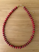 Collar corto de cuentas rojas con pequeñas cuentas doradas entre cada cuenta roja.