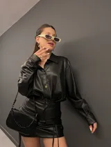 Camisa negra de ecocuero con gamuza interna y botones dorados.