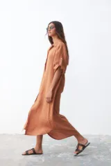 Vestido camisero color ocre de lino, con cuello clásico, mangas 3/4 con botón para sujetar y cierre frontal con botones.