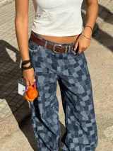 Pantalón de jean ancho (wide leg) de algodón, con diseño de patchwork en tonos de azul que simula un patrón a cuadros, con bordados artesanales a mano en las costuras.