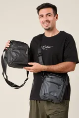 Bandolera negra con correa ajustable y cierre superior.