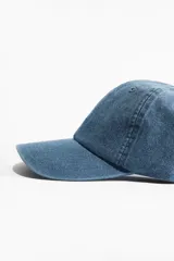 Gorra de sarga de algodón color celeste con bordado de un colibrí blanco en el frente.