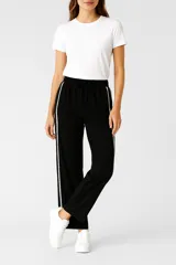 Pantalón negro ancho con rayas blancas laterales y cintura elastizada con cordón ajustable.
