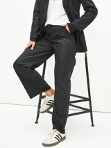 Pantalón negro de vestir con finas rayas verticales blancas, corte recto y tiro alto.