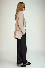 Blazer negro de manga larga con cuello solapa y cierre frontal de un solo botón. Presenta bolsillos delanteros con solapas.