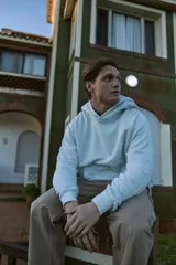 Buzo con capucha celeste, de manga larga y fit loose. Confeccionado en tejido loop back cepillado por dentro, con mangas ranglán, puños de canalé, forro de la misma tela en el interior de la capucha y estampa en goma de tacto suave ubicada en la espalda.