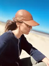 Gorro tipo baseball de cuero ovino color marrón, con logo bordado en el lateral.