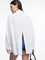 Camisa celeste de calce relajado con abertura en la espalda y mangas largas. Confeccionada en tejido liviano de lino y viscosa. Incluye tres pins decorativos.