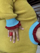 Buzo color marrón con cuello alto y mangas largas terminadas en volados.