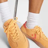 Championes Converse Run Star Trainer color mostaza con detalles en coral y suela marrón.