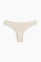 Pack de tres bombachas tipo tanga de algodón acanalado en color crudo, rojo y borgoña, con ribetes de encaje y moño decorativo.