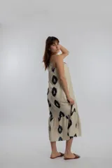 Vestido midi color crema con estampado de óvalos negros, de un solo hombro y corte holgado.