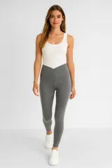 Calza larga gris de poliéster, tiro alto y corte ajustado al cuerpo.